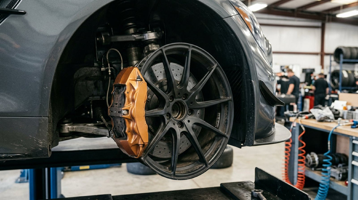 High-performance Mercedes-Benz track brake pads installed in an AMG multi-piston caliper on a ventilated brake rotor.