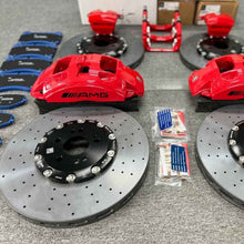 Complete ForzaCCB carbon ceramic big brake kit unboxing, featuring four rotors, red Mercedes AMG calipers, blue brake pads, and mounting hardware.