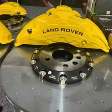 ForzaCCB carbon ceramic brake rotor paired with a yellow multi-piston Land Rover brake caliper.